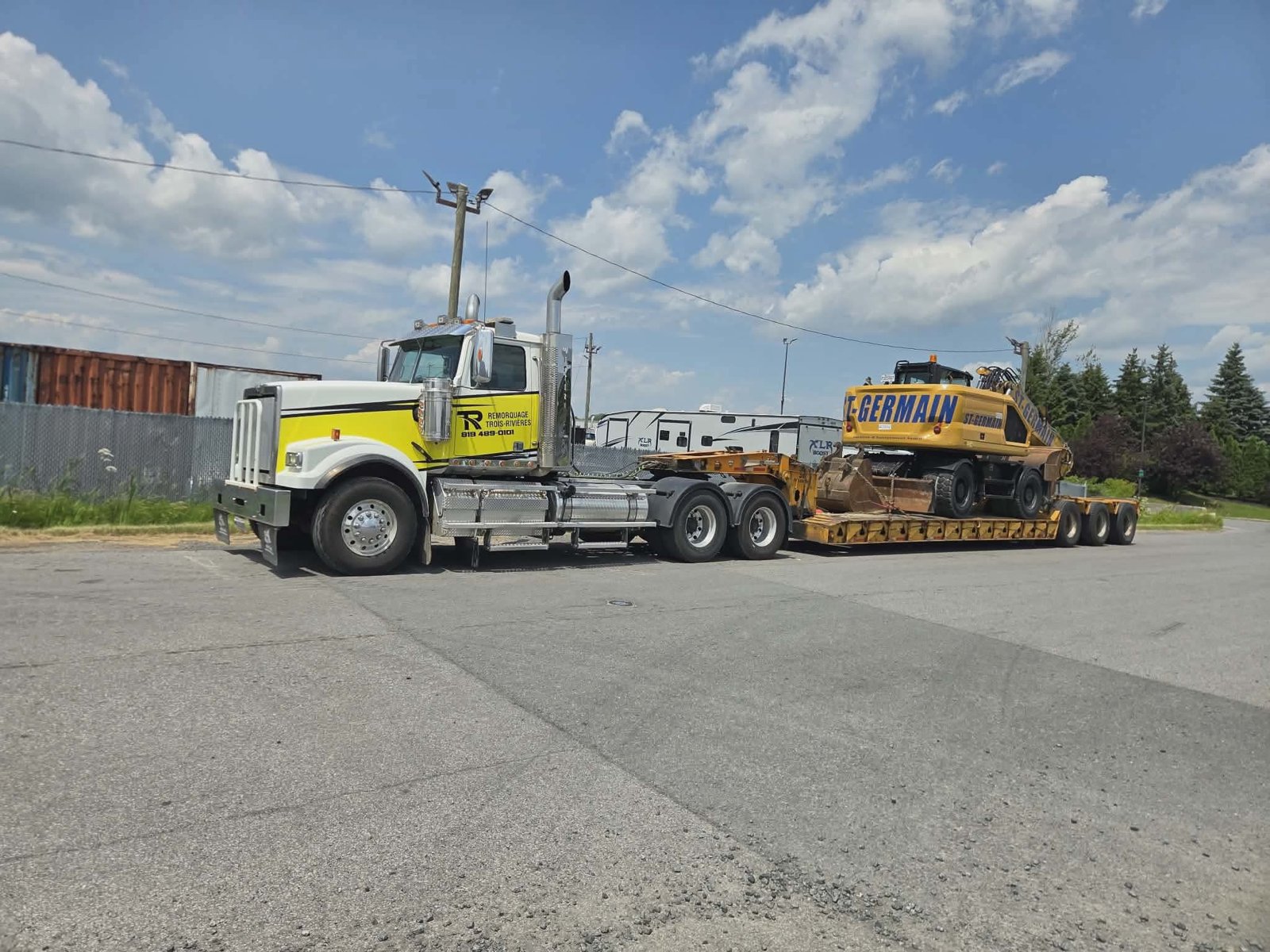 Western Star de Remorquage Trois-Rivières et semi-remorque surbaissée transportant une pelle sur roues
